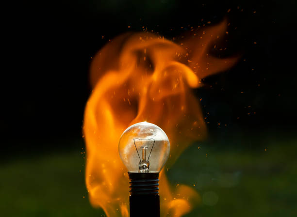 istock Image of an electric light bulb in a flame on a blurred background 1266155579