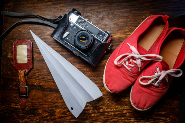 Photography and travel background still life with camera paper airplane and shoes