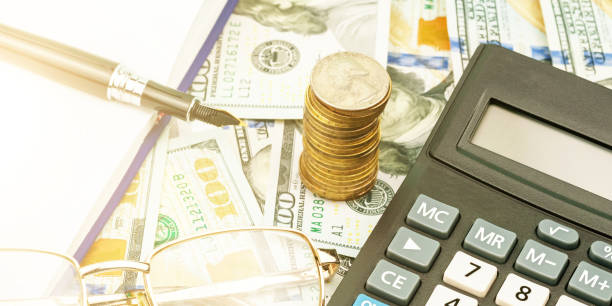 istock calculator banknotes coin stack and fountain pen on table 1266158630