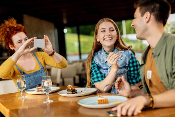 istock Young carefree friends having fun while eating dessert in a cafe. 1266160761