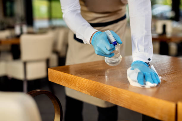 istock Close-up of waiter disinfecting cafe tables after work. 1266161511