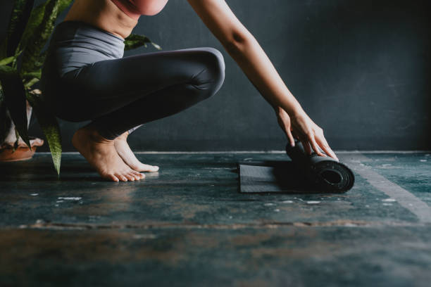 istock Unrecognizable Woman Unrolling her Exercise Mat on the Floor, Home Workouts during the Pandemic Concept 1266161794
