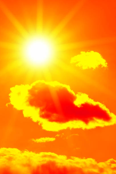istock Bright sun with beautiful beams in the sky with clouds (toned in red) 1266162004