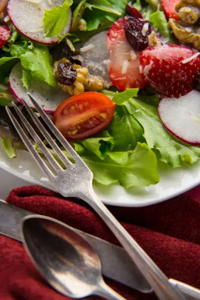 Fresh organic romaine lettuce salad with walnuts radishes and strawberries