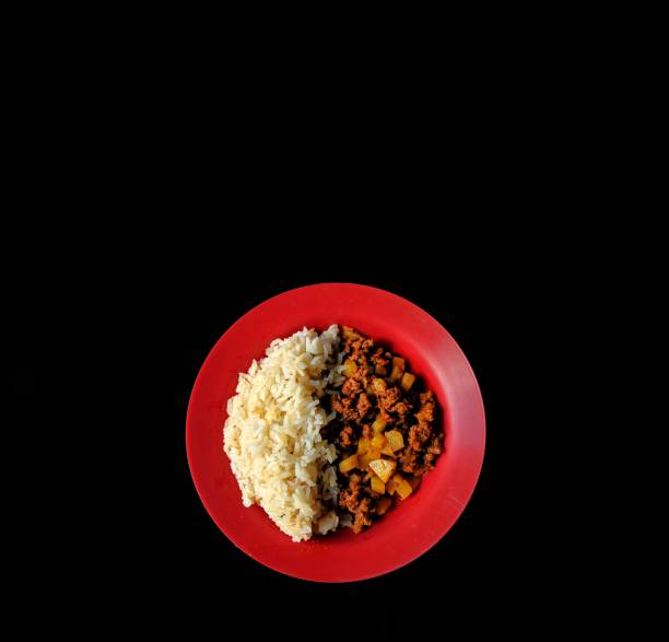 Ground beef with potatoes and rice on black background