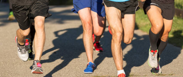 istock Front view of legs of a group of runners on a path 1266165408