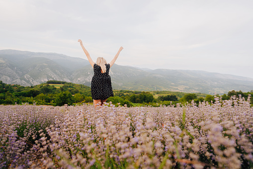 Photo of a young woman running through the lavender field; enjoying the beautiful and peaceful weekend getaway, far from the hustle of the city.