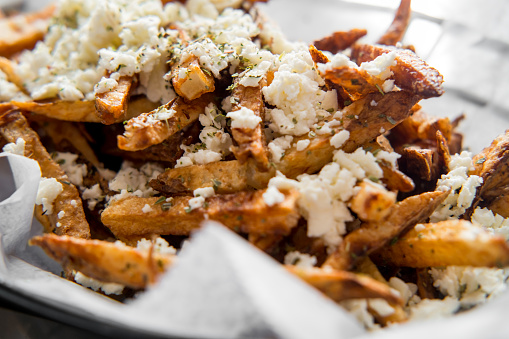 Delicious Mediterranean street cart fried potatoes with feta cheese herbs and spices