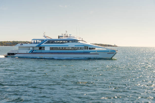 High-speed ferry in navigation on a clear autumn day Photo of a passenger high-speed ferry leaving a harbour on a sunny autum day. Hyannis, MA, USA. passenger craft photos stock pictures, royalty-free photos & images