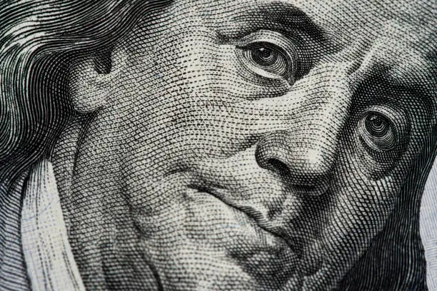 Photo of Benjamin Franklin's portrait on one hundred dollar bill close up
