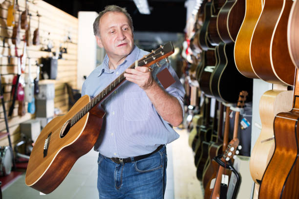istock male choosing acoustic guitar 1266187409