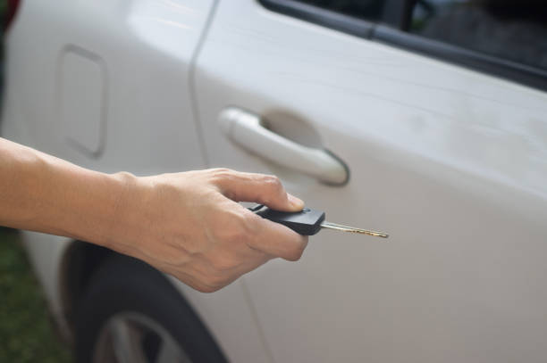 istock Female pressing remote systems key  for lock or unlock car. 1266190078