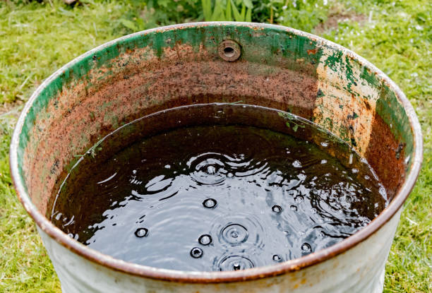istock Old rusty barrel with rain water. Raindrops on water 1266192592