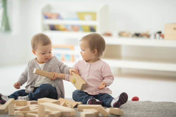 istock Baby sisters playing together 1266193532