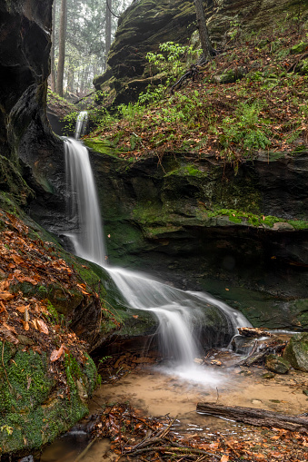 A beautiful ephemeral waterfall flows after heavy rains in a hidden rocky ravine in the Hocking Hills of Ohio.