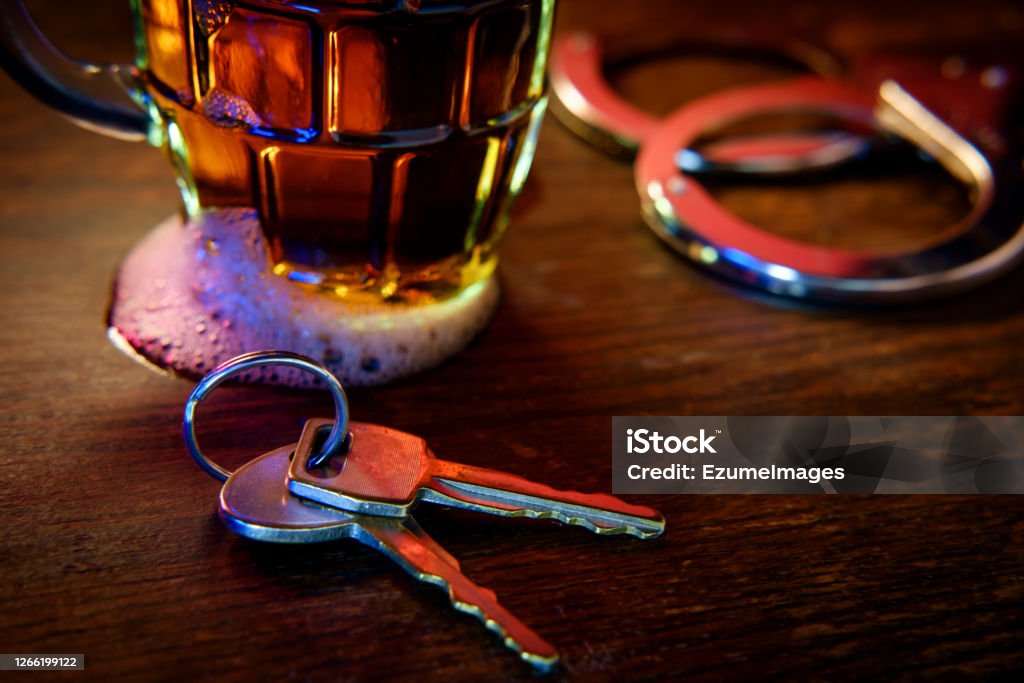 Alcohol Keys Handcuffs Mug of frothy beer with handcuffs and keys symbolizing drunk driving arrest Driving Under The Influence Stock Photo