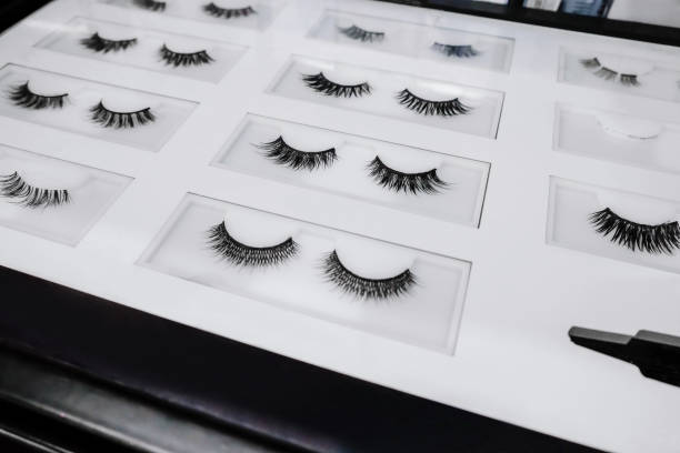 Accentuate Your Eyes with Fake Eyelashes Close-up shot of various fake eyelashes on a beauty store display rack. false lashes stock pictures, royalty-free photos & images
