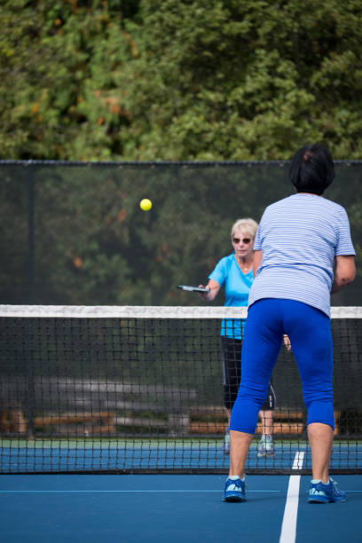istock Seniors enjoy playing tennis together 1266206825