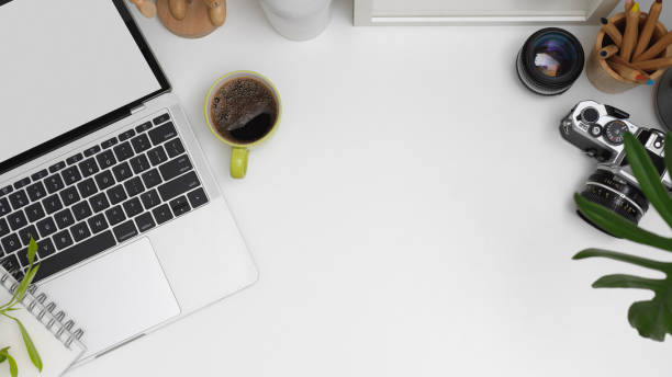 istock Workplace with mock up laptop, camera, stationery, decorations and copy space on white table 1266208454