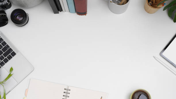 istock Workplace with copy space, laptop, tablet, notebook, books and stationery on white table 1266208493