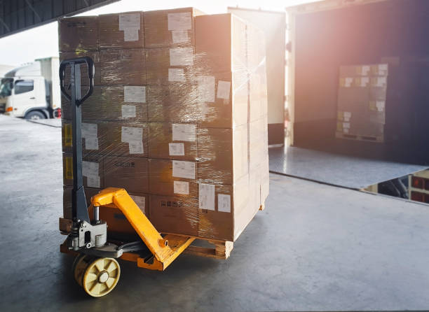 istock Hand pallet truck with pallet goods loading into container truck. Shipment, Cargo freight, Delivery. Logistics and transportation. 1266208546
