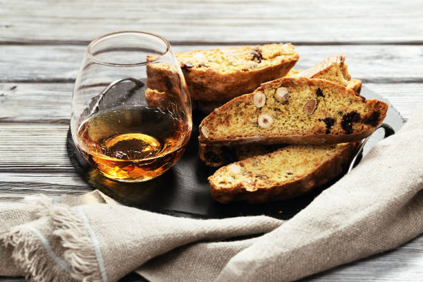 italian biscotti cookies on black slate board and sweet wine vin santo. - biscotti imagens e fotografias de stock