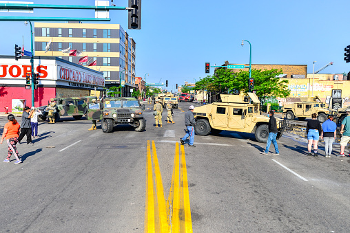 Minneapolis, MN, USA:  5/30/2020 - Damage in Minneapolis streets after protests and rioting occur. Fires still burning in distance after looting and rioting. Road was under construction already.