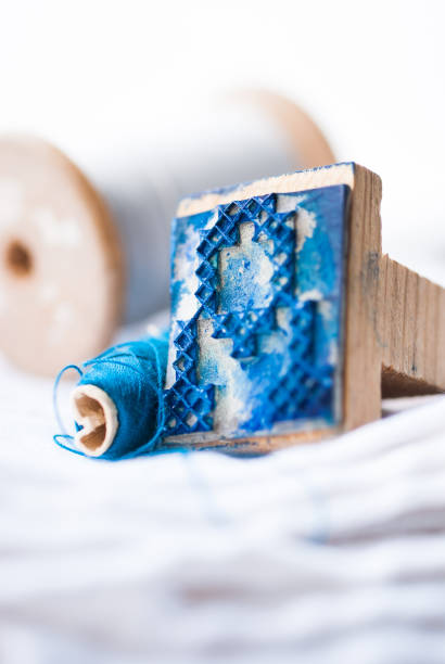 Old, vintage, embroidery stamp with blue ink. Letter A. Spools in background.