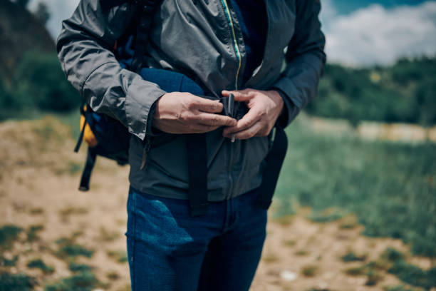 istock Closeup of man buckling backpack on camping trip. 1266215180