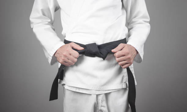 istock Caucasian man fixing his black belt. Karate 1266217815