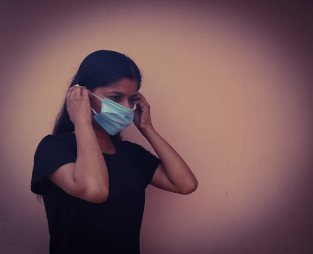 istock Women standing with mask and gloves 1266218599