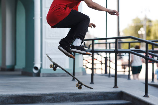 istock Young boy skating trick on skateboard at city 1266220722