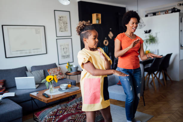 istock Mother and daughter dancing at home 1266223523