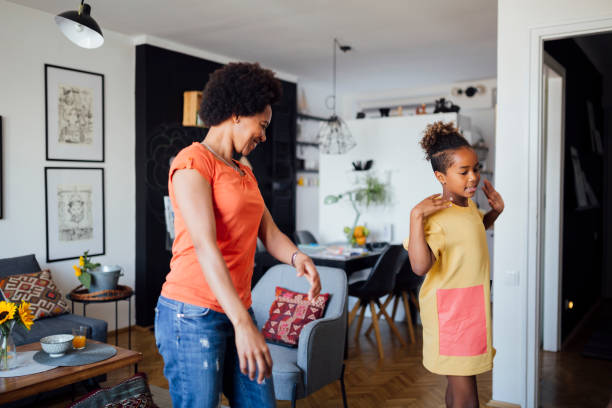 istock Mother and daughter dancing at home 1266224007