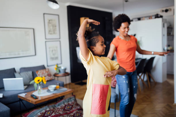 istock Mother and daughter dancing at home 1266224586