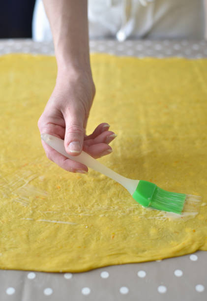 istock Female hands sprinkle round dough on the table 1266224697