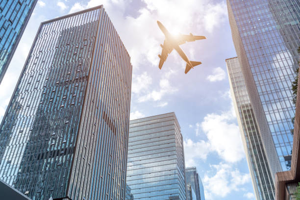 istock plane fly over modern office buildings in downtown. 1266224829