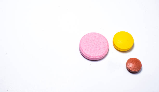 istock One white one yellow and one brown pill on white background. 1266228642