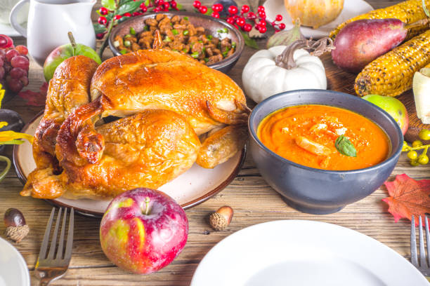 Happy Thanksgiving concept. Thanksgiving day celebration dinner setting with traditional meal and food - green beans, mashed potatoes, cranberry sauce, pumpkin soup, autumn fruits, vegetables