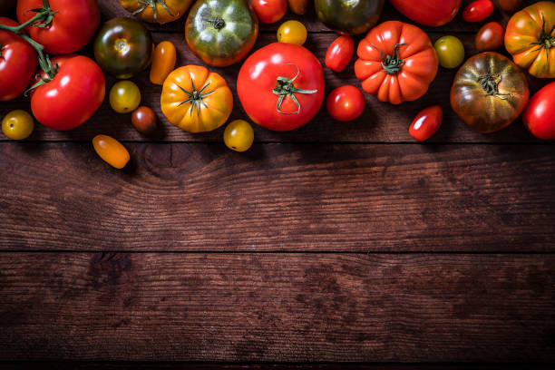 istock Various kinds of tomatoes with copy space on a wooden table 1266238680