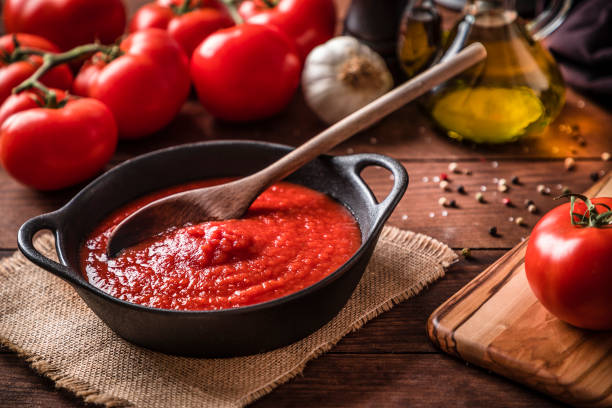 cocinar y condimentar la salsa de tomate - salsa de tomate fotos fotografías e imágenes de stock