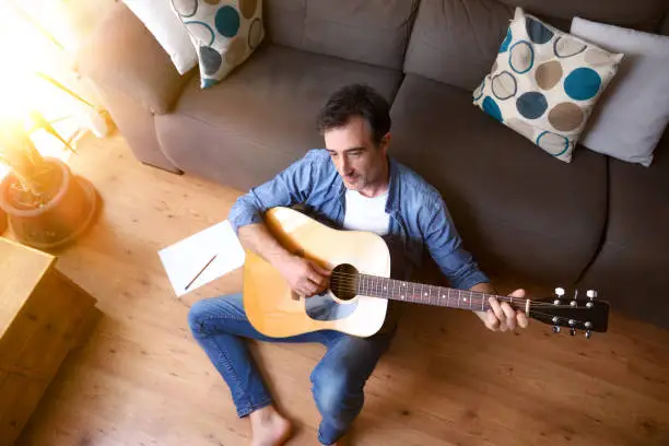 Photo of Man composing for guitar sitting
