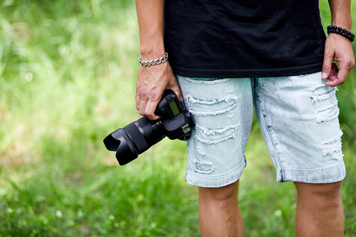 Man photographer with a photo camera in hand outdoor, World photographer day, creative hobby, copy space, place for text, Photography Concepts Professional.
