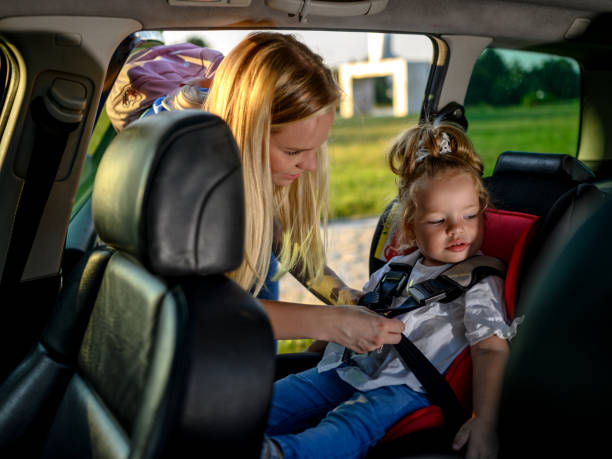 istock Woman putting child in car seat 1266247937