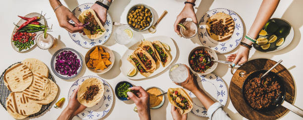 istock Friends having Mexican style Taco dinner with beer and snacks 1266248990