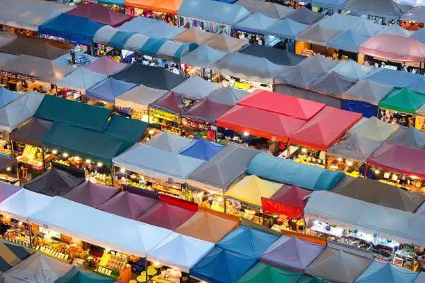 Photo of 01/02/2020 Bangkok, Thailand, Top view of Train Night Market Ratchada (Talad Rot Fai) flea market with plenty of shops with colorful canvas and amazing pattern of roofs near MRT line at night time in Bangkok