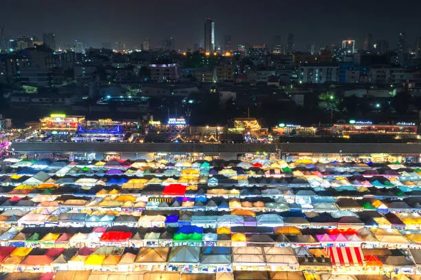 Photo of 02/02/2020 Bangkok, Thailand, Top view of Train Night Market Ratchada (Talad Rot Fai) flea market with plenty of shops with colorful canvas roofs near MRT line at night time in Bangkok