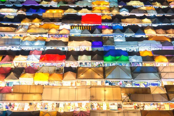 Photo of 01/02/2020 Bangkok, Thailand, Top view of Train Night Market Ratchada (Talad Rot Fai) flea market with plenty of shops with colorful canvas and amazing pattern of roofs near MRT line at night time in Bangkok