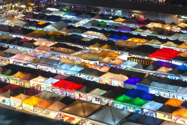 Photo of 01/02/2020 Bangkok, Thailand, Top view of Train Night Market Ratchada (Talad Rot Fai) flea market with plenty of shops with colorful canvas and amazing pattern of roofs near MRT line at night time in Bangkok