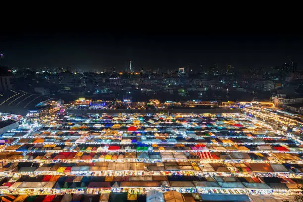 Photo of 02/02/2020 Bangkok, Thailand, Top view of Train Night Market Ratchada (Talad Rot Fai) flea market with plenty of shops with colorful canvas roofs near MRT line at night time in Bangkok